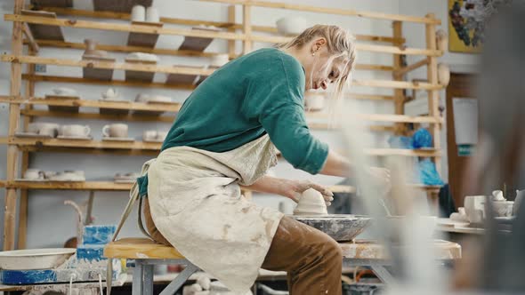 Female Artist Working at Pottery Workshop Sculpting Crockery on Pottery Wheel Tracking Shot Slow