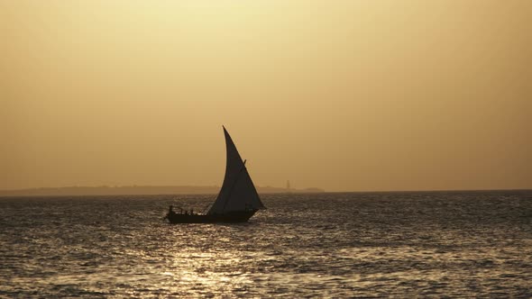 Silhouette African Wooden Dhow Boat Sailing By Ocean at Sunset Zanzibar Africa