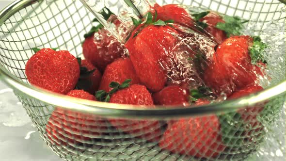 Super Slow Motion on the Strawberries in the Colander Drops Water