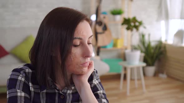 Sad Young Woman with a Burn Scar on Her Face Sitting Alone