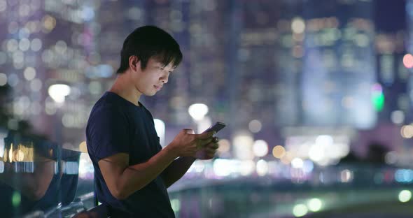 Man use of mobile phone in city at night