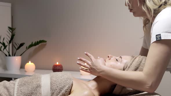 Relaxing massage. Woman receiving head massage at spa salon, side view