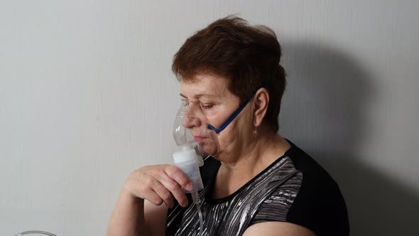 Senior Woman Making Inhalation with a Nebulizer