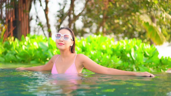 Young asian woman enjoy around outdoor swimming pool for leisure