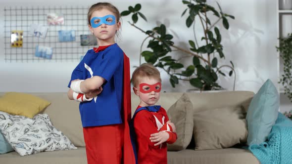 Little Boy and Girl in Superhero Costumes Posing for Camera