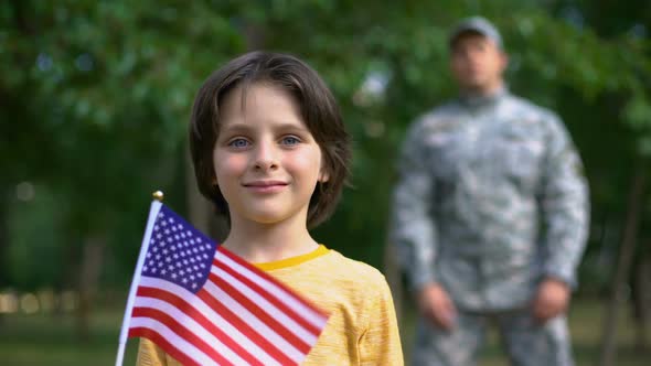 Adorable Boy Holding American Flag, Male Soldier Standing Behind, Safe Future