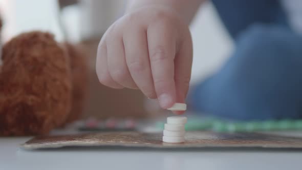 Toddler Sits on Windowsill and Plays with Scattering Pills Without Parent's Control. Dangerous