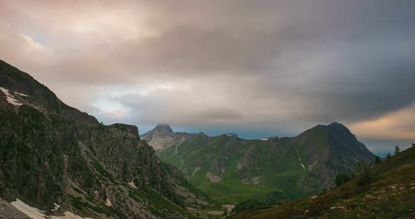 Time lapse, moving clouds over mountain ridges and peaks, storm coming on the Alps