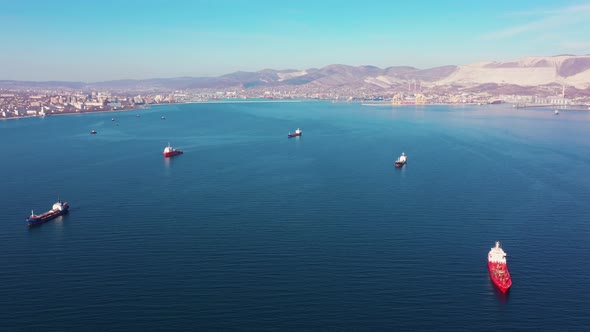 Flight Above Cargo Ships Sailing in Open Ocean Against Coast