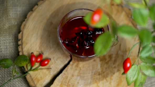 Top View In Slow Motion Tincture Of Herbs And Red Berries, Tea From Medicinal Rose Hips, Homeopathy.