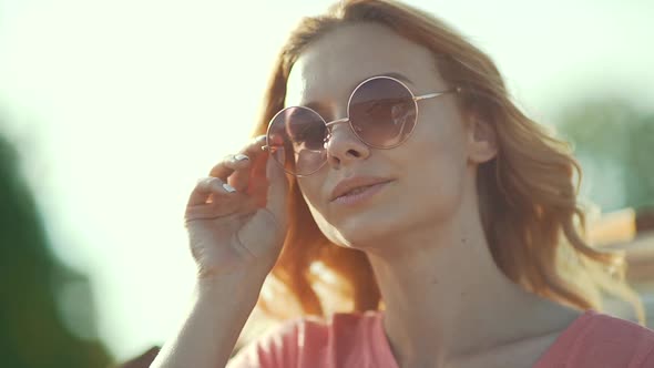 Beautiful Girl In Sunglasses Enjoying Summer Sun. Happy Smiling Woman Having Fun On Wind 