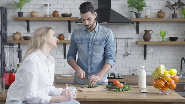 Handsome Middle Eastern Man Cutting Cucumber for Healthful Salad and Arguing with Beautiful