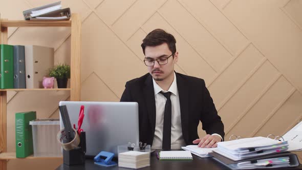 Office Worker Gets Very Upset By Lifting Several Pages of Working Documents Front View
