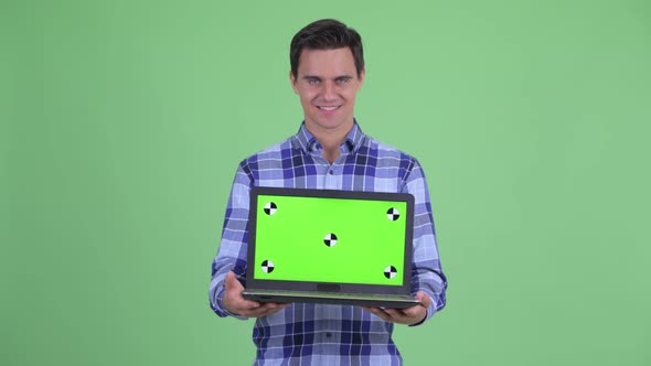 Happy Young Handsome Hipster Man Showing Laptop and Looking Surprised