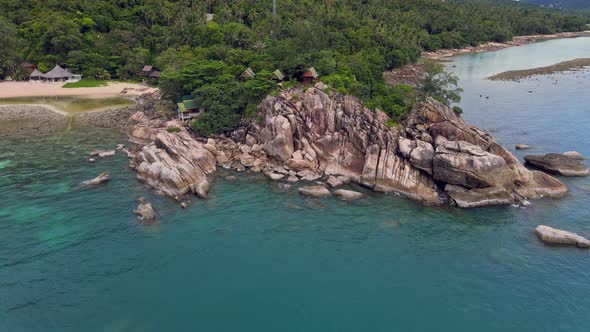 Aerial View of Island Beach with Bungalow and Rocky Coastline at Haad Khom Beach