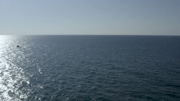 Aerial wide shot of a single motorboat cross the sea water, drone shot