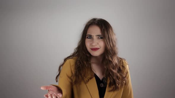 Confused Woman is Moving Her Hand in Front and Frowning in Slow Motion on White Background