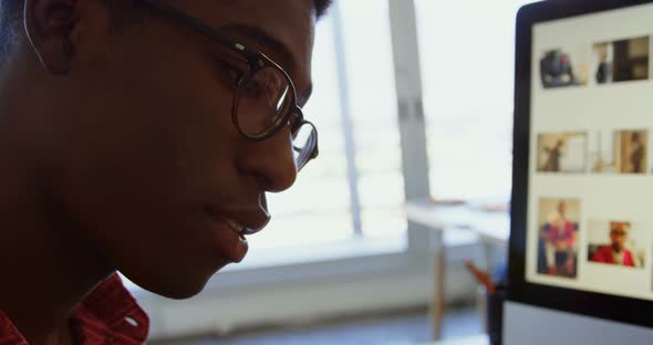 Side view of African American male graphic designer working at desk in office 4k