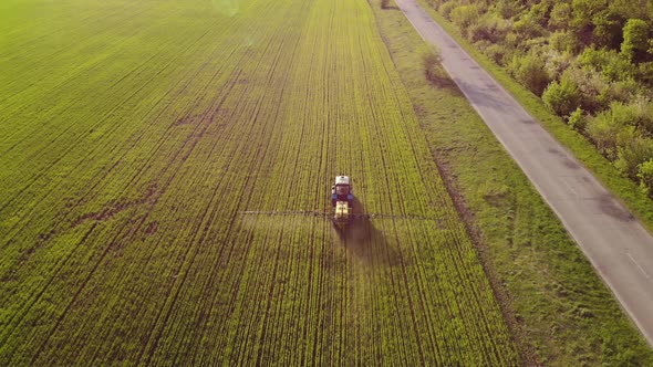 Aerial View of Farming Tractor Spraying on Field with Sprayer