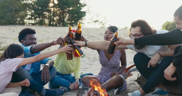 Team of Friends is Sitting By Lake on Sand Beach the Last Days of Vacation They Spend Time Together