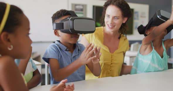 Video of happy caucasian female teacher and african american pupils wearing vr headsets