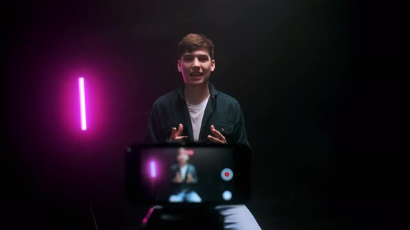 A Young Guy Shoots a Blog in a Black Studio