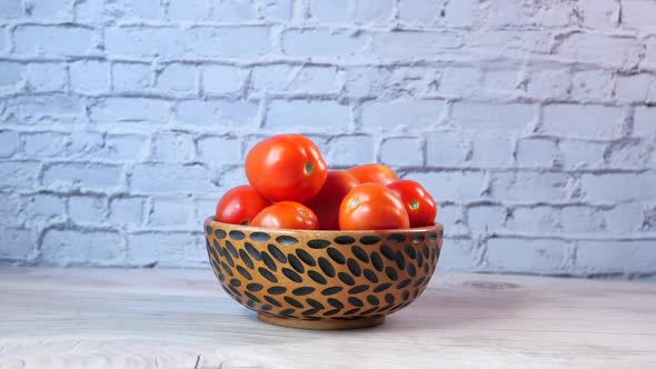 Hand Of Person Picking Tomatoes From a Bowl 