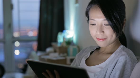 Woman watching on digital tablet at night