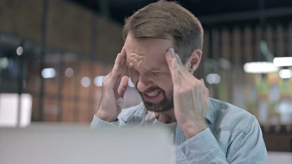 Close Up of Tense Man with Headache at Work