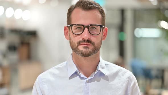 Portrait of Serious Businessman Looking at Camera 