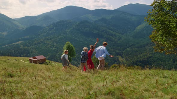 Family Enjoying Outdoor Games on Green Hill