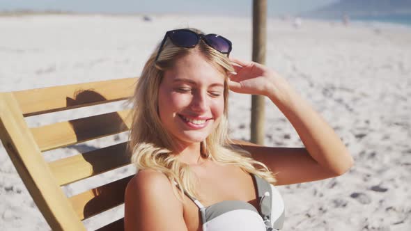 Caucasian woman sitting on a sunbed on the beach