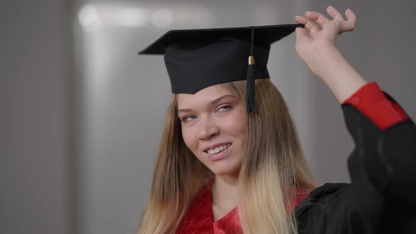 Closeup Portrait Happy Confident Graduate Woman Posing in Graduation Gown and Cap Tassel on the Left