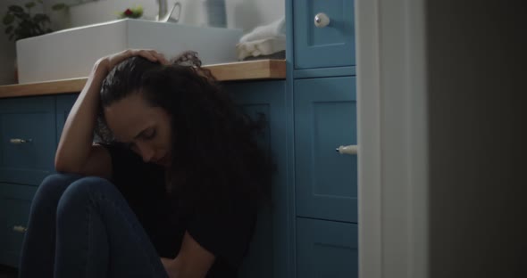 Depressed woman sitting on the floor