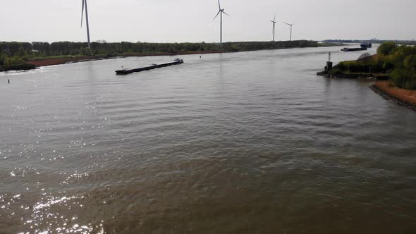 Aerial Over Calm Waters Of Oude Maas With Approaching Ship And Still Windmills In Background. Dolly