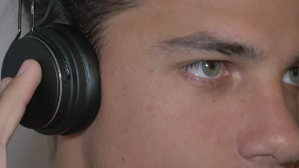 An inspired Youngman with headphones enjoying music in a close-up view.