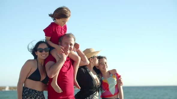 Medium Shot of Big Family Standing on Beach Looking at Camera