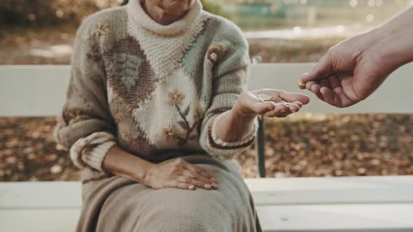 Old Vulnerable Lost or Homeless Woman Getting Coins. Dementia and Mental Issues Concept 