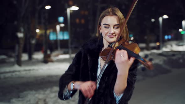 Pretty Girl Stands in the Middle of the Square and Holds the Violin