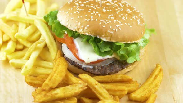 Delicious grilled hamburger with potato chips on wooden board