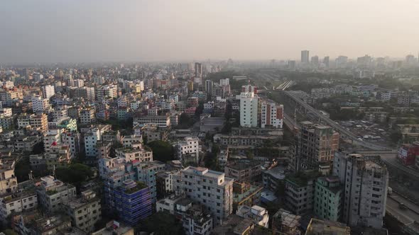 Aerial View Over Dense Asian Metropolitan Cityscape Condominiums With Highway Running Past. Dolly Ri