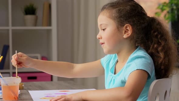 Little Girl with Colors Drawing Picture at Home
