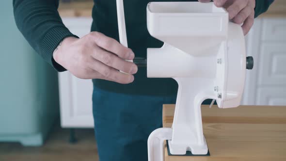 Man Installs and Tests Handle To Flour Grinder in Kitchen