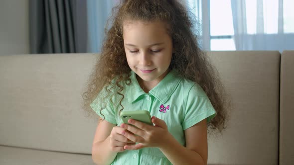 Cute Child Girl Schoolboy Holds a Phone Kid Using Smartphone Child Browsing the Internet Talking on