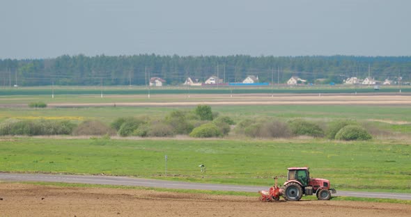 Tractor Plowing Field In Warm Spring Day Season