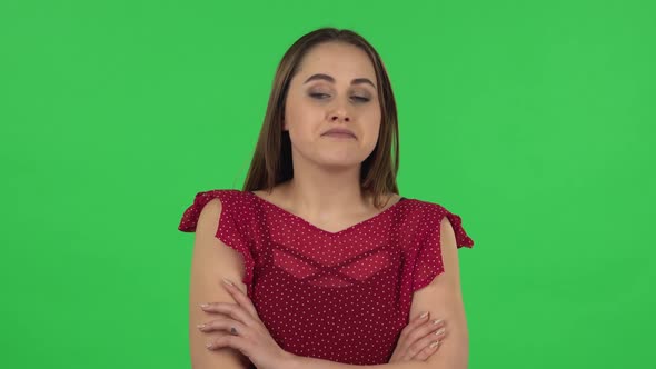 Portrait of Tender Girl in Red Dress Is Listening To Boring Information and Yawning. Green Screen