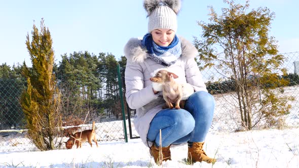 Woman Playing With Dog Outside. Winter