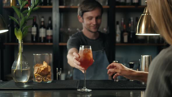 Woman Hands Toasting with Aperol Spritz Cocktails Woman in Bar Take Alcohol From Bartender