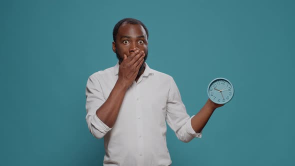 Shocked Man Checking Time on Clock and Running Late to Work