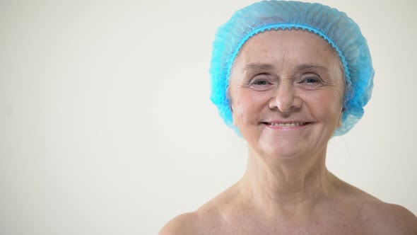 Smiling Elderly Female in Protective Hat Looking to Camera, Plastic Surgery